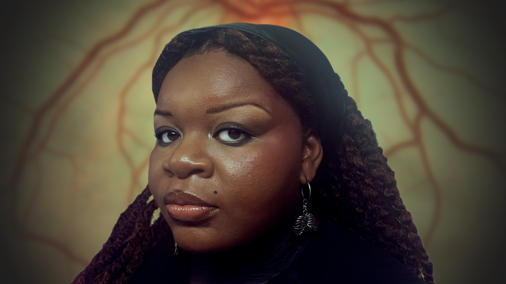 A woman with long braids wearing a black shirt, standing confidently with a neutral expression.