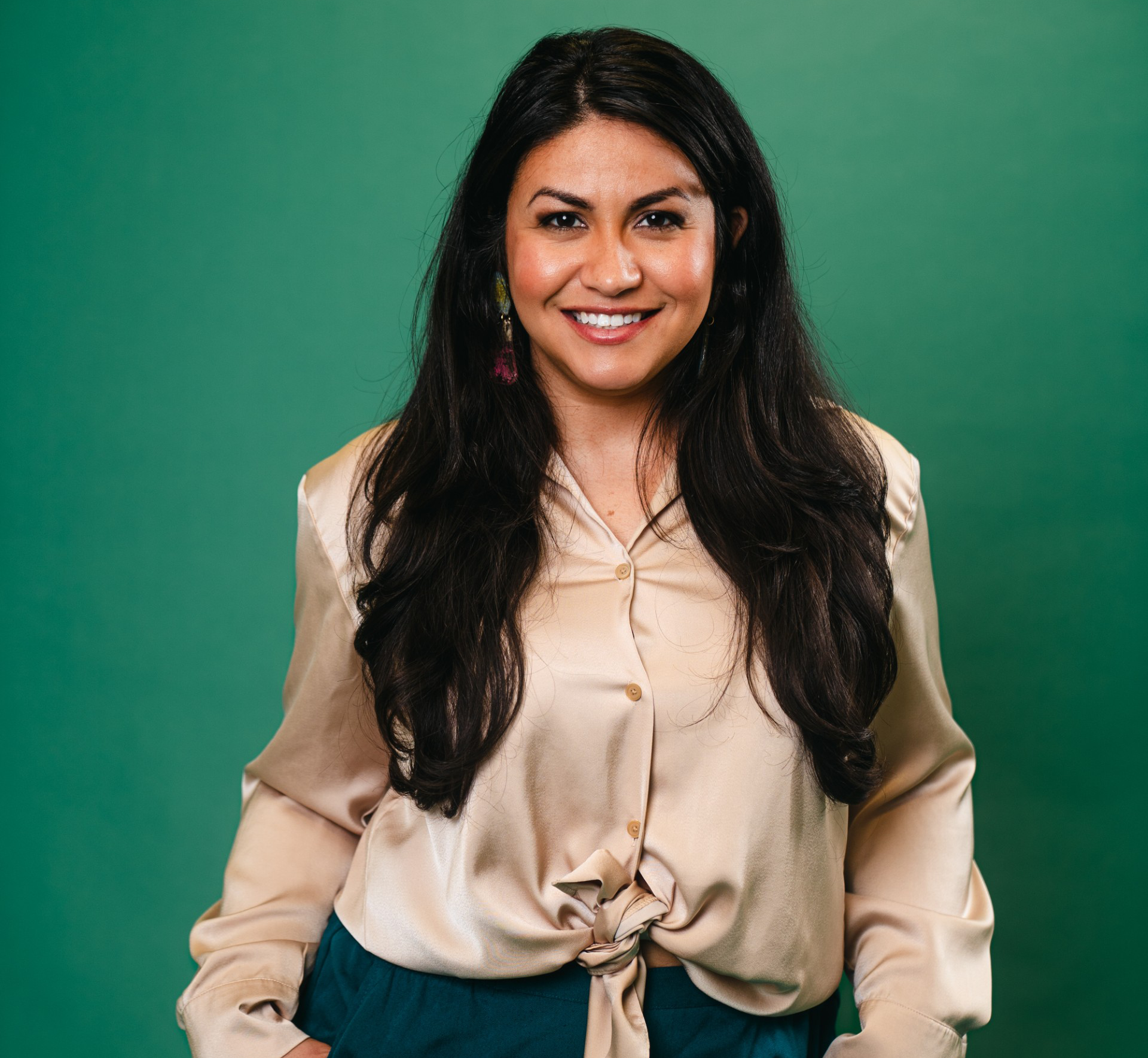 A person with dark hair is set against a green background.