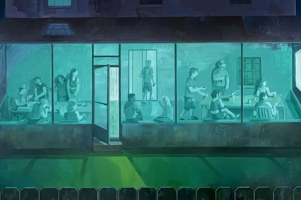 A nighttime view through a large window shows people inside a brightly lit teal room engaged in various activities.