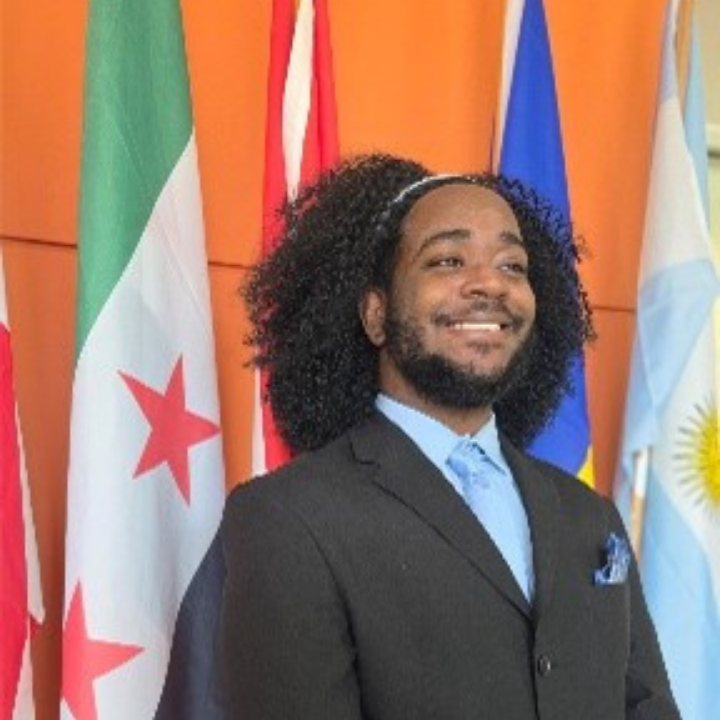 a professional shot of Dale Mabrey campus's chief of staff standing in front of a national flag.