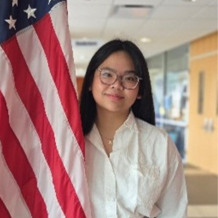 a professional shot of Dale Mabrey campus's President of The Senate standing in front of a national flag.