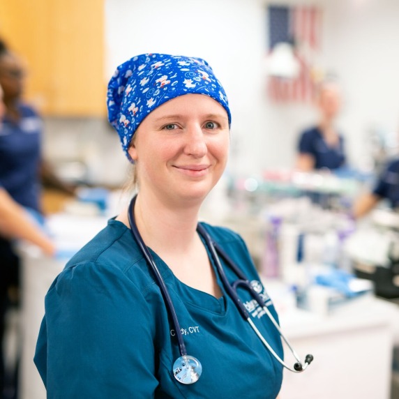 a female veterinary student smiling at the camera while inside the vet lab at the plant city campus.