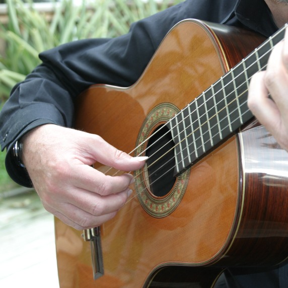 Close up photograph of Professor Mark Switzer playing guitar