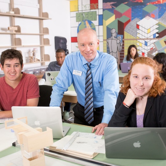 Architecture instructor in classroom helping students one-on-one