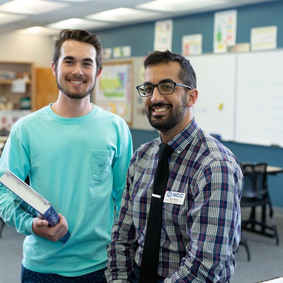 Student and staff member standing and smiling. 