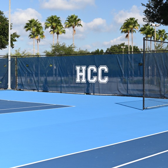 Tennis court with HCC Hawks banners in background