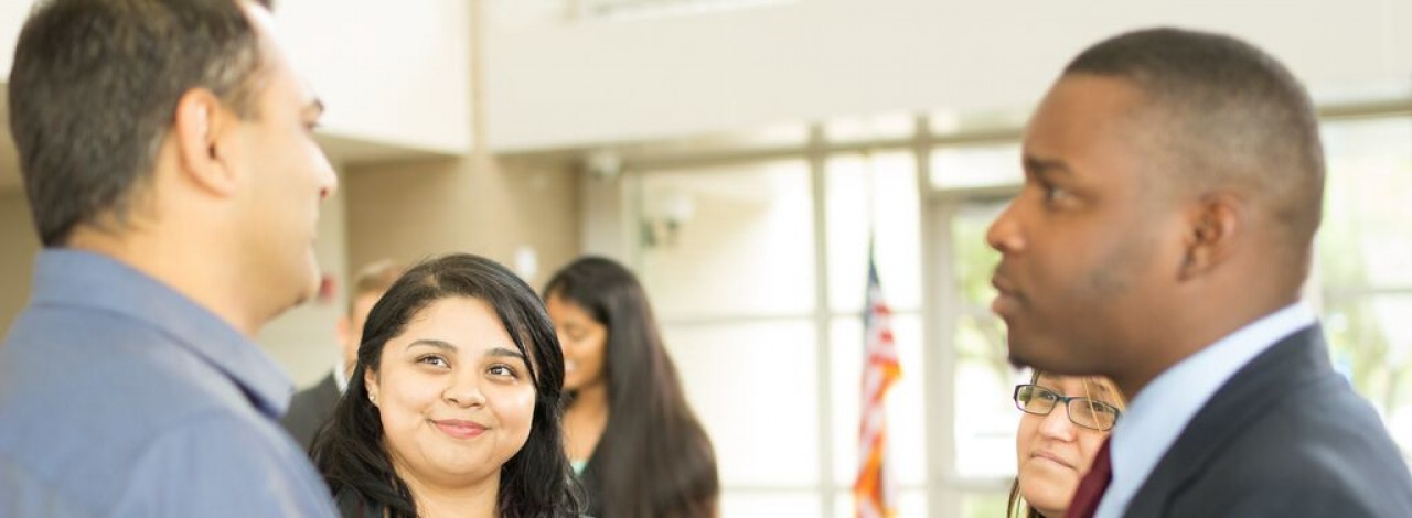 Business students conversing with one another. 