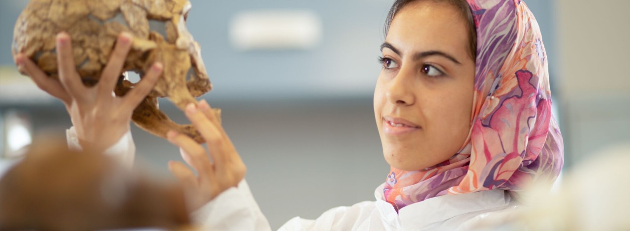 Female student closely studying a skull