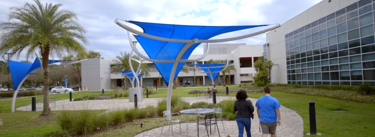 two students walking across Dale Mabry campus