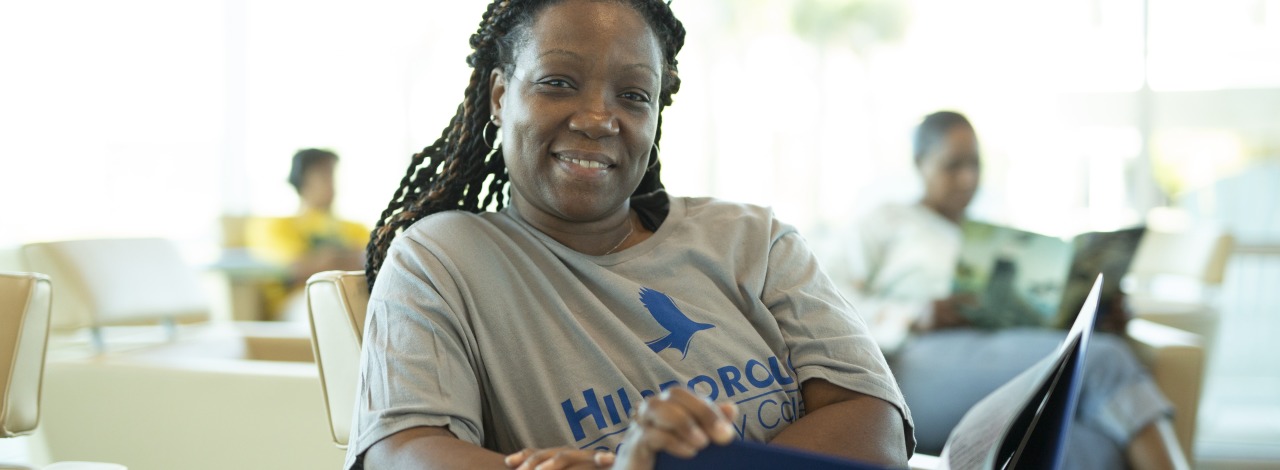 African American woman sitting in a lounge with an opened binder on her lap