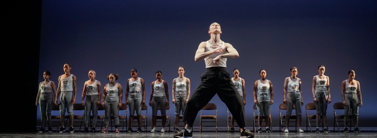 Dancer on stage in with student dancers in the background