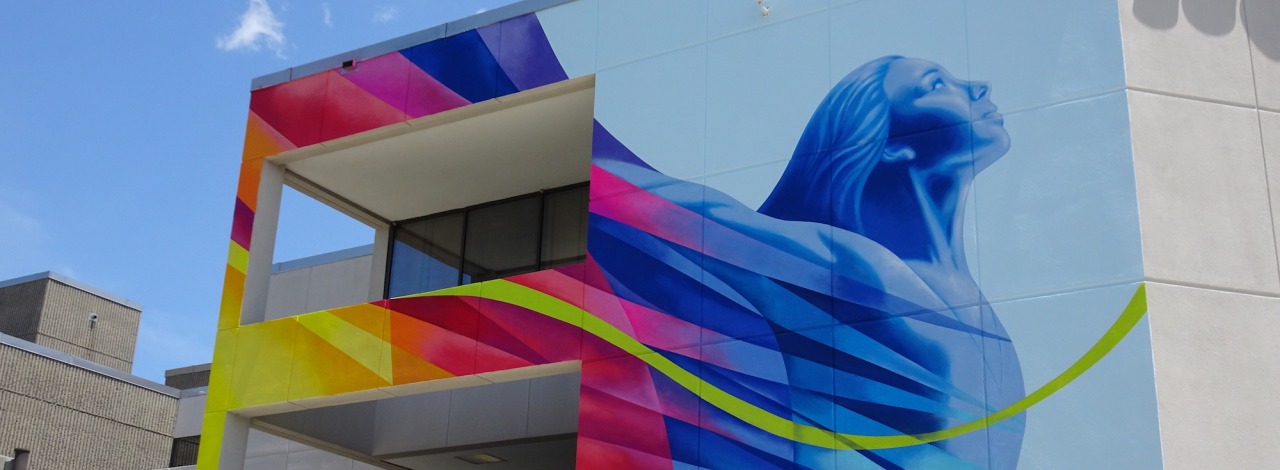 Colorful mural of a woman with arms lifted